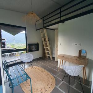 a room with a loft bed and two chairs and a table at À l'aube du sacré coeur in La Plaine des Palmistes