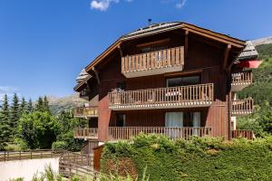 a large wooden house with balconies on a hill at Carpe Diem à L'Alpaga - Centre station in La Salle Les Alpes +8 photos