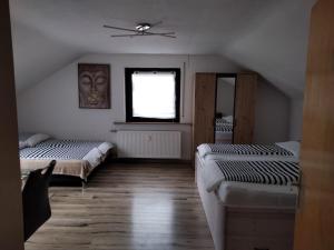 a attic room with two beds and a window at El Refugio GD in Schwäbisch Gmünd