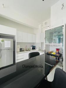 a kitchen with white cabinets and a counter top at Diamond@Troika in Kota Bharu