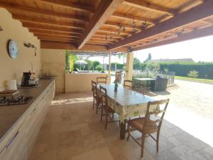 una cucina e una sala da pranzo con tavolo e sedie di Villa moderne dans la tranquillité de la campagne a Caderousse