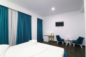 博尔什Memi Hotel的一间卧室配有一张床、两把椅子和一张书桌
