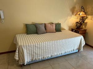 uma cama num quarto com um candeeiro sobre uma mesa em Departamento Céntrico em Goya