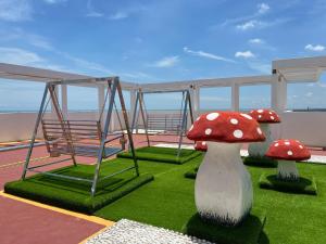 un balcón con 2 setas rojas en la hierba en Hot Picks SmartTV Netflix Seaview Homestay Sekinchan, en Sekinchan
