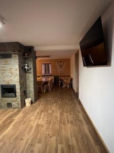 a living room with a hard wood floor and a fireplace at Apartament i Pokoje u Łowisza in Ciche