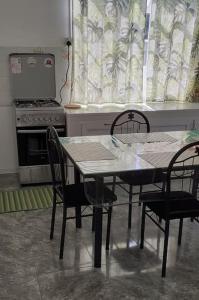 Il comprend une cuisine équipée d'une table, de chaises et d'une cuisinière. dans l'établissement Villa Bella Quatre Cocos, à Trou dʼ Eau Douce