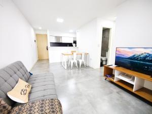 uma sala de estar com um sofá e uma televisão de ecrã plano em Tu lugar en Córdoba - Departamento Premium em Córdova