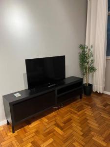 un centro di intrattenimento nero con TV a schermo piatto in soggiorno di Apartamento Nictheroy a Niterói