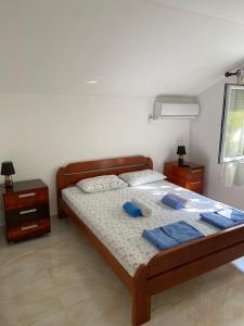 um quarto com uma cama com toalhas azuis em Lotus House Dodoši em Dodoši