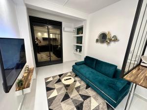 een woonkamer met een blauwe bank en een spiegel bij Cyrus appartements in Pointe-à-Pitre