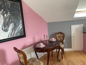 a dining room with a table and a painting of a horse at Kilkenny rental The Folly Lodge minutes from city centre R95RYC8 in Kilkenny