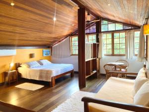 a bedroom with a bed and a table and chairs at Pousada Morro do Forte in Paraty +99 photos
