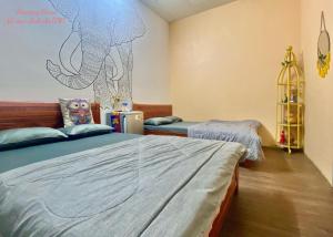 1 dormitorio con 2 camas y una pared con un dibujo en la pared en Amazing House, en Buôn Ðũng