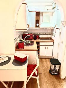 a small kitchen with a table and a sink at Ana's Apartment parking gratuito in Málaga