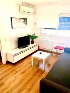 a living room with a flat screen tv and a table at Ana's Apartment parking gratuito in Málaga