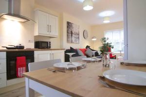 a kitchen and living room with a table and chairs at Newly refurbished village flat in Cullybackey