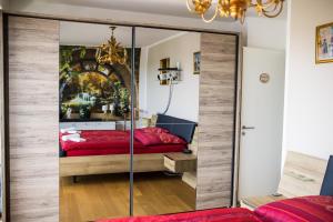 Schlafzimmer mit einem verspiegelten Schrank und einem roten Bett in der Unterkunft Zentrum und Whirlpool 107m2 Händel-Suite by Meis - Perfekt für längere Aufenthalte! in Halle an der Saale