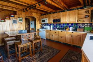 eine Küche mit Holzschränken sowie einem Tisch und Stühlen in der Unterkunft Dragonwood Retreat 