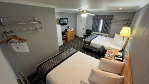a hotel room with two beds and a television at Purple Sage Motel in Snyder
