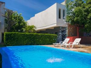 a swimming pool with two chairs and a house at Marbello Ariau Hotel in Fortaleza
