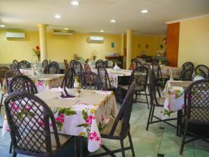 福塔萊薩的住宿－Marbello Ariau Hotel，用餐室配有桌椅和鲜花