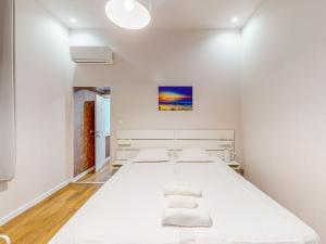 1 dormitorio con 1 cama blanca grande y toallas. en Markoni 2, en Burgas