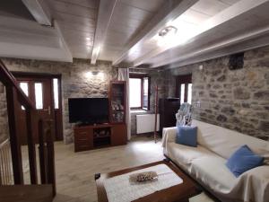 a living room with a couch and a tv at Κατοικία Πανόραμα, Πραγματευτή Λεωνιδίου, Τ.Κ.22300 in Leonidion