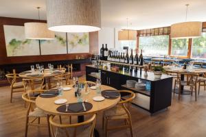 a restaurant with tables and chairs and wine bottles at Hotel Xalet del Golf in Puigcerdà
