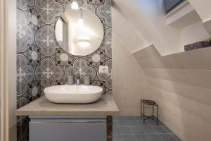 a bathroom with a sink and a mirror at Suite La Scala del Borgo in Cisternino