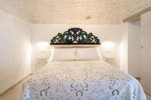 ein Schlafzimmer mit einem Bett mit einer weißen Tagesdecke in der Unterkunft Suite La Scala del Borgo in Cisternino