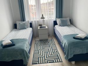 a bedroom with two twin beds and a rug at Apartament Natalia in Hel