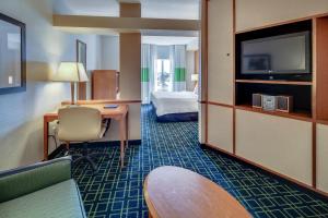 Habitación de hotel con cama, escritorio y TV. en Fairfield Inn and Suites Jacksonville Beach en Jacksonville Beach