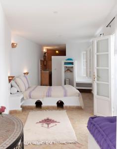 a bedroom with a large bed and a table at La Casa Del Mar in Essaouira