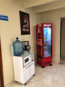 ein alter Coca-Cola-Kühlschrank neben einer Mikrowelle in der Unterkunft HOTEL TORRELUZ PLAZA in Popayan