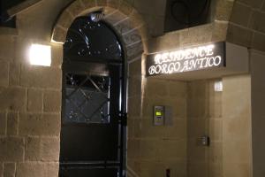 ディーゾにあるResidence Borgo Anticoの古文字を読む看板付きの建物への扉