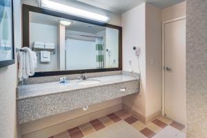 ein Badezimmer mit einem Waschbecken und einem großen Spiegel in der Unterkunft Fairfield Inn and Suites Jacksonville Beach in Jacksonville Beach