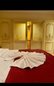 a white bed with a red blanket on top of it at Luxury apartments in sanstefano in Alexandria