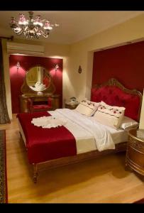 Luxury apartments in sanstefano في الإسكندرية: غرفة نوم بسرير كبير ومرآة