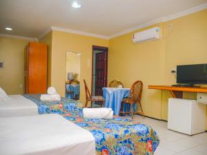 a room with two beds and a table and chairs at Marbello Ariau Hotel in Fortaleza