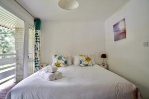 a bedroom with a white bed with towels on it at Special 2 Bedroom Home in White Cross in Saint Columb Major