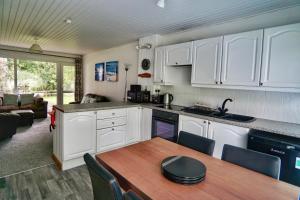 a kitchen with white cabinets and a wooden table at Special 2 Bedroom Home in White Cross in Saint Columb Major