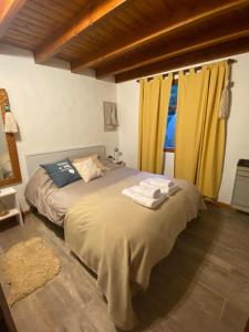 Schlafzimmer mit einem großen Bett und gelben Vorhängen in der Unterkunft Patagonia Ali in San Carlos de Bariloche