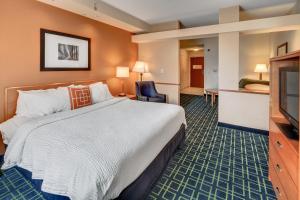 Habitación de hotel con cama y TV de pantalla plana. en Fairfield Inn and Suites Jacksonville Beach, en Jacksonville Beach