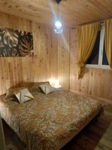 - une chambre avec un lit dans une pièce dotée de murs en bois dans l'établissement chambre d'hôtes Ô rendez-vous, à Roquefeuil