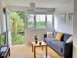 a living room with a blue couch and a table at Stylish & Tranquil Flat with Excellent Connections in London