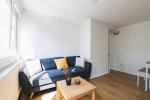 a living room with a blue couch and a table at Stylish & Tranquil Flat with Excellent Connections in London