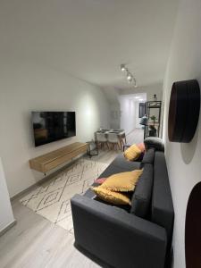 a living room with a black couch and a tv at Mar Menor Elisa Apartment in Santiago de la Ribera