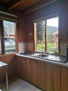 a kitchen with a sink and a window at Cabaña Rossbach Puyuhuapi in Puerto Puyuhuapi +12 photos