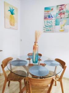 ラスパルマス・デ・グランカナリアにあるLoft Santa Catalina Parkのガラステーブル(椅子4脚付)と花瓶