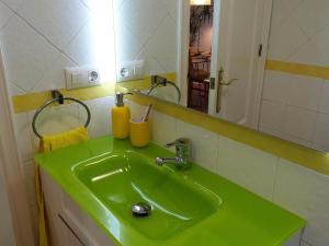 un lavandino verde in un bagno con specchio di Apartamento Córdoba con encanto LUBI II a Cordoba